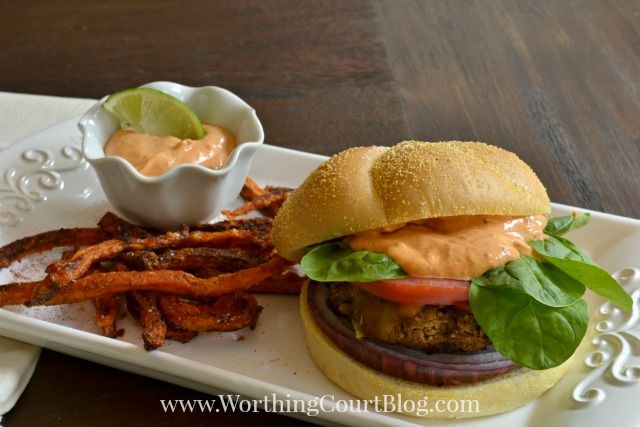 There are sweet potato fries on the plate beside the burger.